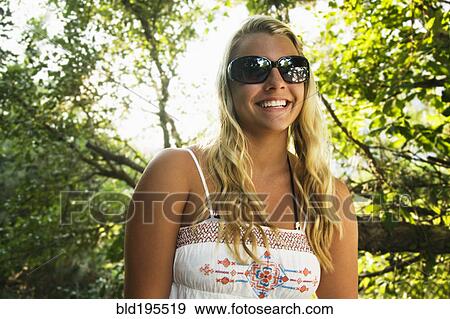 Mixed race teenage girl smiling under tree View Large Photo Image Stock Photo - Mixed race teenage girl smiling under tree. Fotosearch