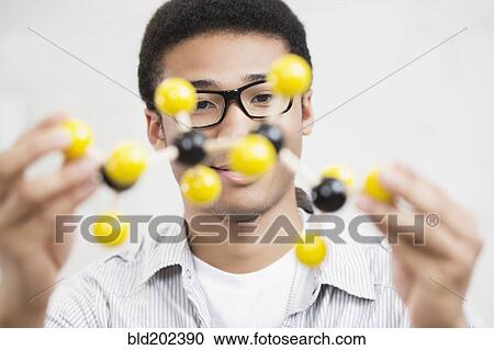 Mixed race teenager holding chemistry model View Large Photo Image Stock Image - Mixed race teenager holding chemistry model. Fotosearch