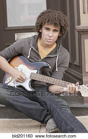 Mixed race teenager playing electric guitar View Large Photo Image Stock Image - Mixed race teenager playing electric guitar. Fotosearch