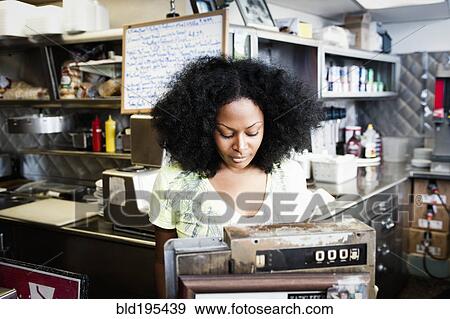 Mixed race waitress at cash register in diner View Large Photo Image Stock Photo - Mixed race waitress at cash register in diner. Fotosearch