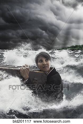 Mixed race woman clinging to trunk in stormy sea View Large Photo Image Stock Photo - Mixed race woman clinging to trunk in stormy sea. Fotosearch