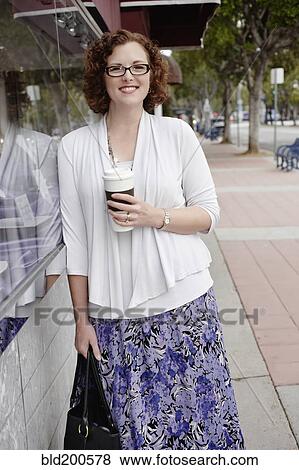 Mixed race woman drinking coffee on sidewalk View Large Photo Image Stock Photo - Mixed race woman drinking coffee on sidewalk. Fotosearch