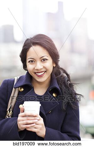 Stock Photo - Mixed race woman drinking coffee. Fotosearch