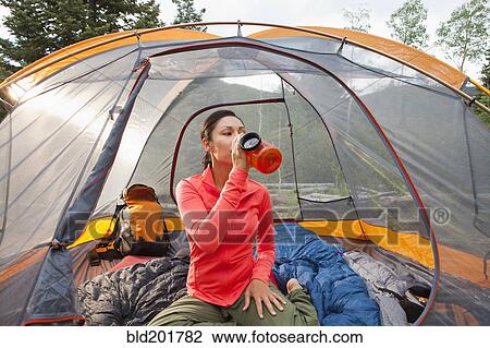 Mixed race woman drinking in tent View Large Photo Image Stock Image - Mixed race woman drinking in tent. Fotosearch