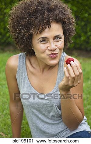 Mixed race woman eating strawberry View Large Photo Image Stock Image - Mixed race woman eating strawberry. Fotosearch