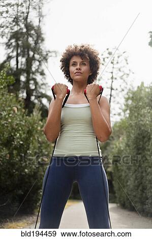 Mixed race woman exercising in park View Large Photo Image Stock Photo - Mixed race woman exercising in park. Fotosearch