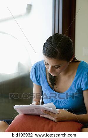 Stock Image - Mixed race woman filling out forms. Fotosearch