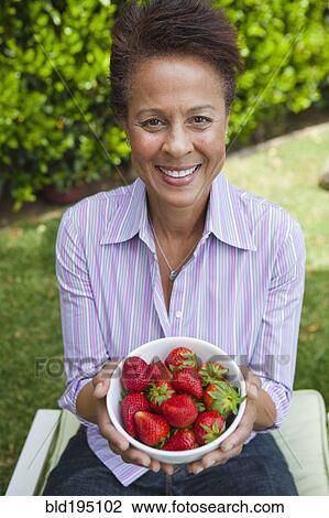 Mixed race woman holding a bowl of strawberries View Large Photo Image Stock Image - Mixed race woman holding a bowl of strawberries. Fotosearch