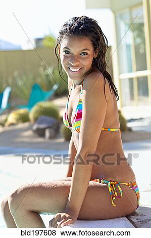 Mixed race woman in bikini sitting at poolside View Large Photo Image Stock Photo - Mixed race woman in bikini sitting at poolside. Fotosearch