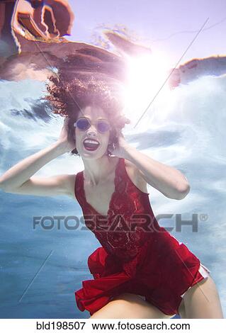 Mixed race woman in clothes swimming underwater View Large Photo Image Stock Photo - Mixed race woman in clothes swimming underwater. Fotosearch