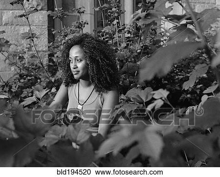 Stock Image - Mixed race woman in garden. Fotosearch