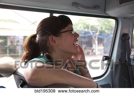 Stock Photo - Mixed race woman laughing in car. Fotosearch
