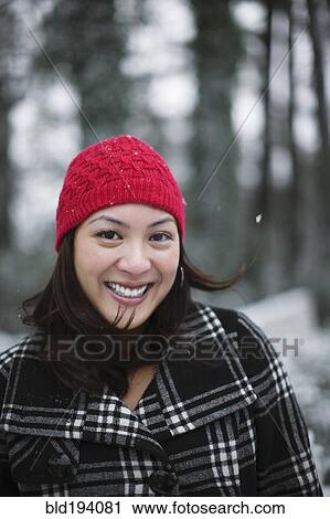 Stock Image - Mixed race woman outdoors in snow. Fotosearch