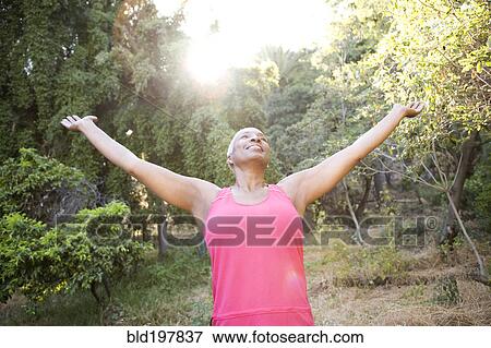 Mixed race woman outdoors with arms raised View Large Photo Image Stock Photo - Mixed race woman outdoors with arms raised. Fotosearch
