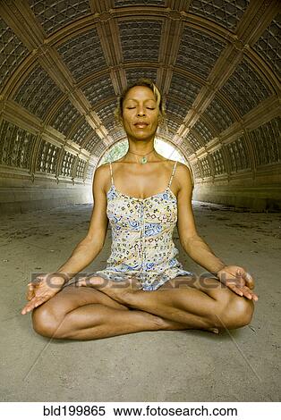 Stock Photography - Mixed race woman practicing yoga. Fotosearch