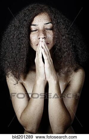 Stock Photo - Mixed race woman praying. Fotosearch