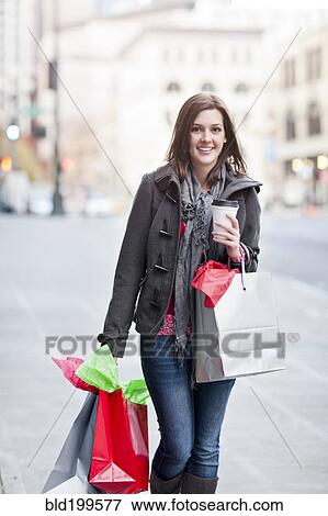 Mixed race woman shopping and drinking coffee View Large Photo Image Stock Photo - Mixed race woman shopping and drinking coffee. Fotosearch