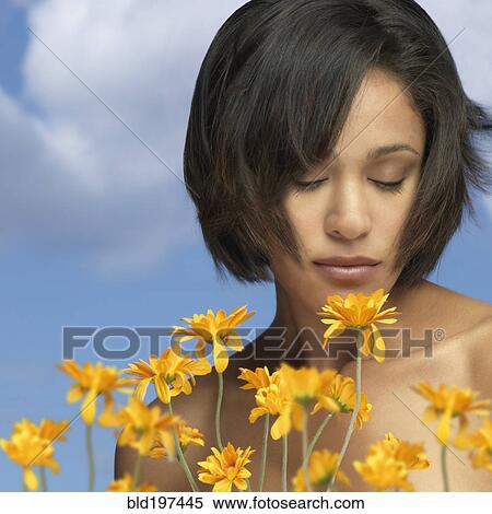 Mixed race woman smelling flowers View Large Photo Image Stock Photography - Mixed race woman smelling flowers. Fotosearch