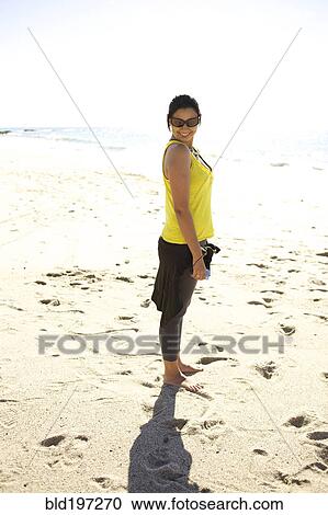 Mixed race woman standing on beach View Large Photo Image Stock Image - Mixed race woman standing on beach. Fotosearch