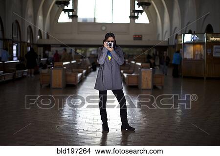 Mixed race woman taking photographs in historic building View Large Photo Image Picture - Mixed race woman taking photographs in historic building. Fotosearch