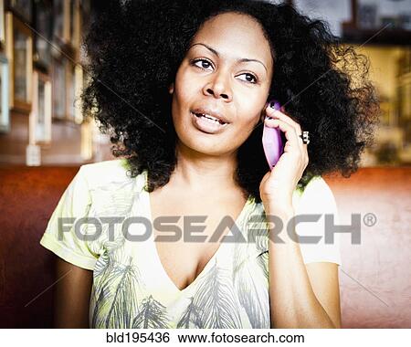 Stock Photograph - Mixed race woman talking on cell phone. Fotosearch