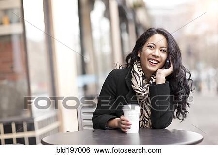 Mixed race woman talking on cell phone and drinking coffee View Large Photo Image Stock Photograph - Mixed race woman talking on cell phone and drinking coffee. Fotosearch