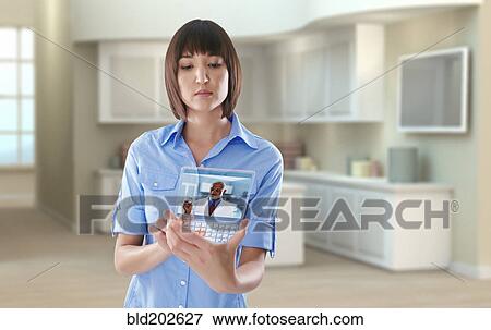 Stock Photo - Mixed race woman using digital tablet in office. Fotosearch