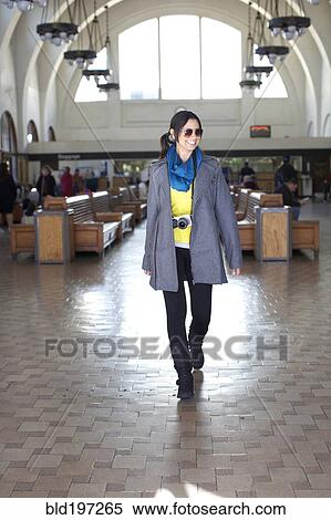 Stock Photography - Mixed race woman walking in historic building. Fotosearch