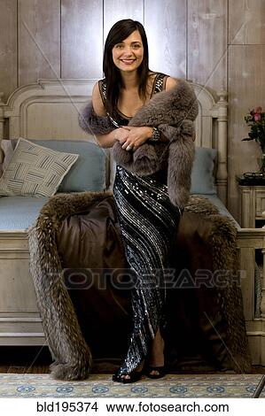 Mixed race woman wearing evening gown and fur coat in bedroom View Large Photo Image Picture - Mixed race woman wearing evening gown and fur coat in bedroom. Fotosearch