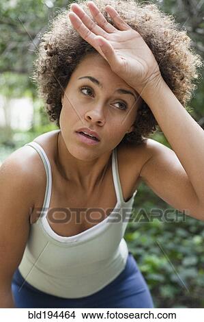 Mixed race woman wiping forehead View Large Photo Image Picture - Mixed race woman wiping forehead. Fotosearch