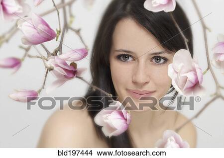 Mixed race woman with flowers in foreground View Large Photo Image Picture - Mixed race woman with flowers in foreground. Fotosearch