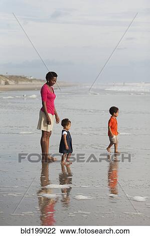 Mother and children enjoying beach together View Large Photo Image Stock Image - Mother and children enjoying beach together. Fotosearch
