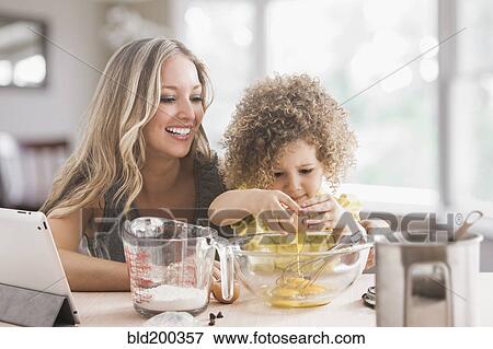 Stock Photo - Mother and daughter baking together. Fotosearch