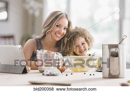 Stock Photo - Mother and daughter baking together. Fotosearch