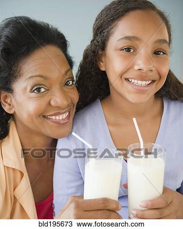 Mother and daughter drinking milk together View Large Photo Image Stock Image - Mother and daughter drinking milk together. Fotosearch