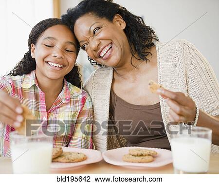 Mother and daughter eating cookies and milk together View Large Photo Image Stock Image - Mother and daughter eating cookies and milk together. Fotosearch