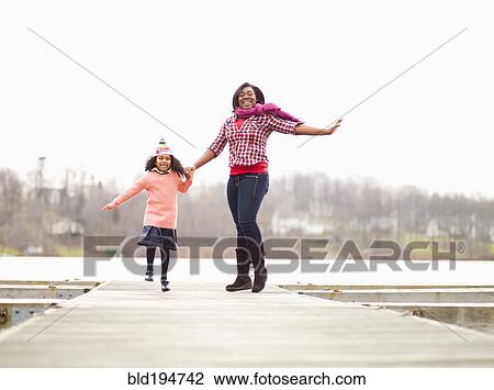 Stock Image - Mother and daughter enjoying walking outdoors. Fotosearch
