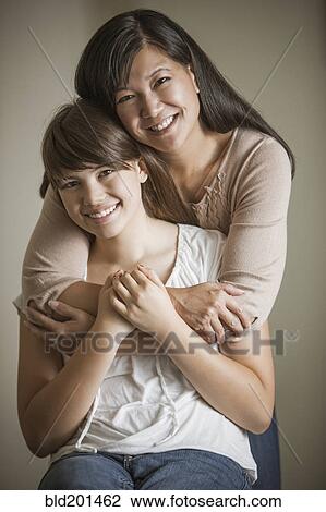 Stock Image - Mother and daughter hugging. Fotosearch
