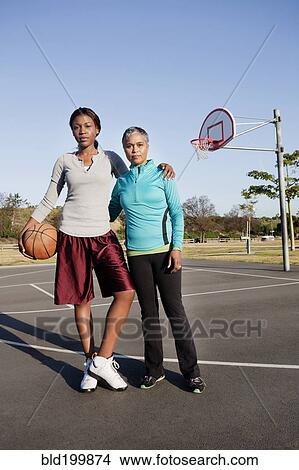 Picture - Mother and daughter playing basketball. Fotosearch