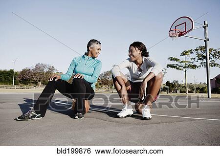Stock Photograph - Mother and daughter playing basketball. Fotosearch