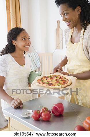 Mother and daughter preparing pizza for dinner View Large Photo Image Stock Photo - Mother and daughter preparing pizza for dinner. Fotosearch