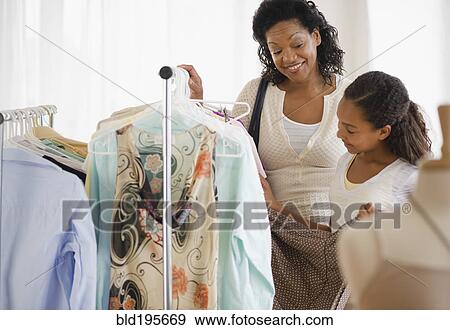 Stock Photo - Mother and daughter shopping for clothing together. Fotosearch