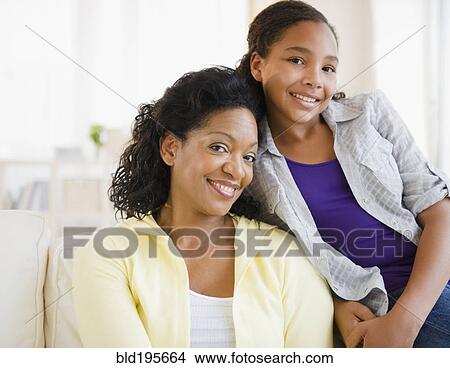 Picture - Mother and daughter smiling in living room. Fotosearch