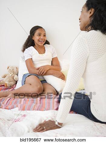 Stock Photo - Mother and daughter talking in bed. Fotosearch
