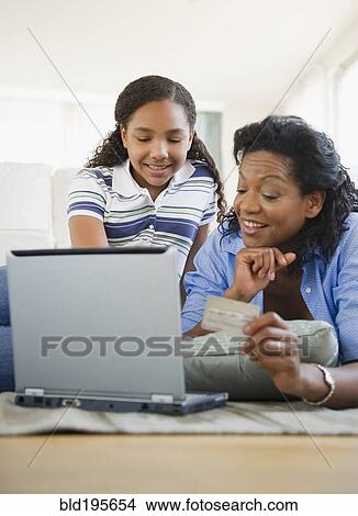 Mother and daughter using credit card online View Large Photo Image Picture - Mother and daughter using credit card online. Fotosearch