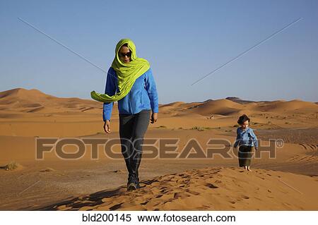 Stock Photography - Mother and son walking in desert. Fotosearch