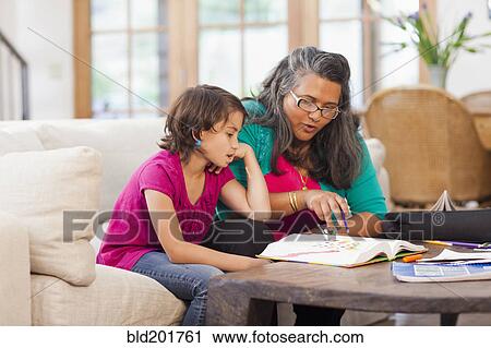Stock Image - Mother helping daughter with homework. Fotosearch