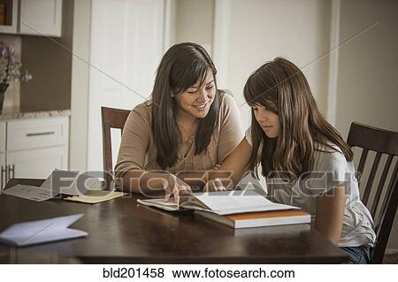 Mother helping daughter with homework View Large Photo Image Stock Photo - Mother helping daughter with homework. Fotosearch