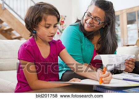 Stock Photo - Mother helping daughter with homework. Fotosearch