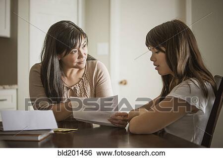 Stock Photograph - Mother helping daughter with homework. Fotosearch